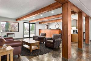 a living room with couches chairs and a table at Baymont by Wyndham Whitefish in Whitefish