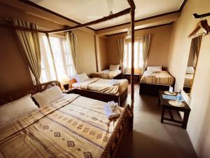 una camera da letto con tre letti e una finestra di New Hotel Castle a Pokhara