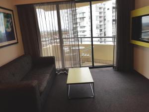 a living room with a couch and a coffee table at Parramatta Hotel Apartment in Sydney