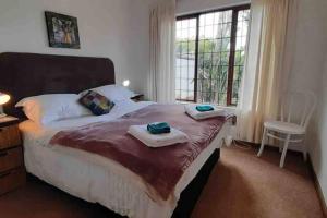 a bedroom with a large bed with towels on it at The Spotted Owl in Cape Town