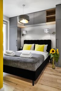 una camera da letto con un grande letto con cuscini gialli di HOUSEHOST Apartment :Miodowa 42/4a a Cracovia