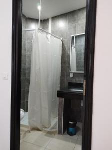 HOTEL OLYMPIC DJERBA في Djerba: حمام مع دش مع ستارة دش