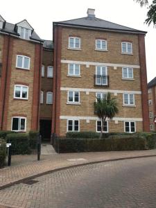 a large brick building with a palm tree in front of it at Lovely 3-bedroom apartment in Colchester in Colchester