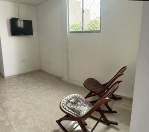 dwa bujane krzesła w pokoju z telewizorem w obiekcie Apartamento amoblado w mieście Sincelejo