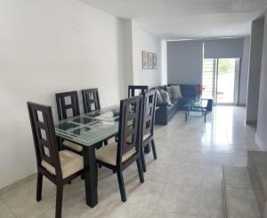 comedor con mesa de cristal y sillas en Apartamento amoblado, en Sincelejo