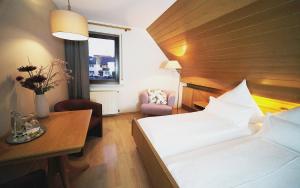 Habitación de hotel con cama, mesa y silla en Gasthof Hirsch, en Schollbrunn