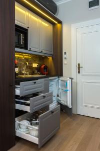 a kitchen with an open cabinet with dishes in it at Apáca 30 Apartman **** Győr in Győr