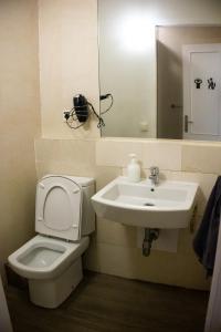 a bathroom with a sink and a toilet and a mirror at Onefam Sungate in Madrid
