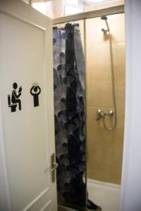 a bathroom with a shower with a man sitting on a toilet at Onefam Sungate in Madrid