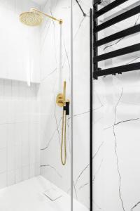 a shower in a bathroom with white tiles at HOUSEHOST Apartment: Św.Gertrudy 10/2.11 in Krakow