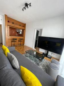 salon z kanapą i telewizorem z płaskim ekranem w obiekcie Calle Orense, Madrid w Madrycie