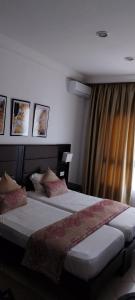 HOTEL OLYMPIC DJERBA في Djerba: غرفة نوم بسرير كبير ونافذة