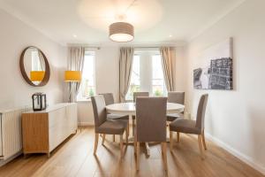 a dining room with a table and chairs and a mirror at Abbey Villa Central Boutique House with Parking in St. Andrews
