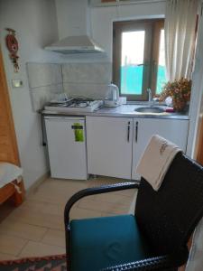 a kitchen with a sink and a stove and a chair at Cirali Kus Yuvası in Cıralı