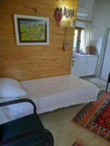1 dormitorio con 1 cama en una pared de madera en Cirali Kus Yuvası en Cıralı
