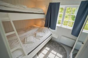a small bedroom with bunk beds and a window at Koie Family in Stranda