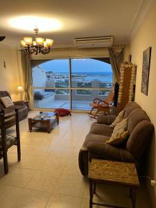 a living room with a couch and a large window at LA VISTA Ain Elsokhna 1&2 Chalet in Ain Sokhna