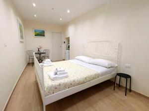 Un dormitorio con una cama blanca con toallas. en Dal Pupo 2, en Bari