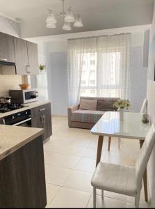 a kitchen and living room with a table and a couch at Luxury apartment in Chişinău