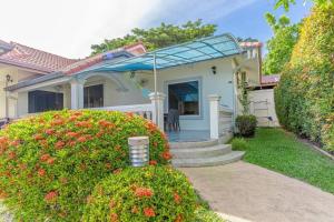 une maison dotée d'une terrasse couverte avec une chaise. dans l'établissement Resort 5-3BR Huge Pool, BBQ, 300m-Beach, 8 mins to Walking Street, à Pattaya (sud)