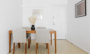 里約熱內盧的住宿－Tabas Lindíssimo apê 2 quartos - Leblon LB0032，一间带桌子和白色椅子的用餐室