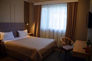 a hotel room with a bed and a window at Vila Camino in Satu Mare