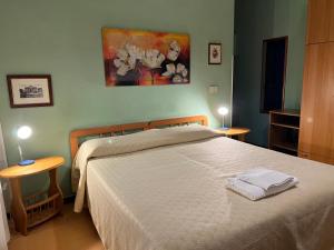 ein Schlafzimmer mit einem Bett mit zwei Tischen und einem Gemälde in der Unterkunft B&B San Michele a Porta Pia in Rom
