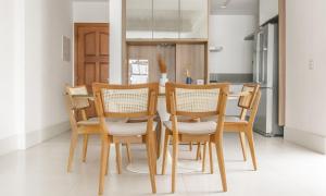 y cocina con mesa, sillas y nevera. en Tabas Aconchegante ap 3qtos no Leblon LB0025 en Río de Janeiro