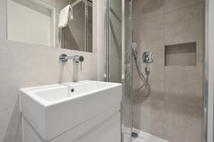 a white bathroom with a sink and a shower at St James House Serviced Apartments by Concept Apartments in London