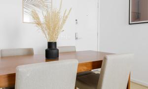 a dining room table with chairs and a vase with grass at Tabas Lindíssimo apê 2 quartos - Leblon LB0032 in Rio de Janeiro