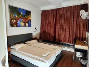 a bedroom with a bed and a desk and a window at Hotel Holland Lodge in Utrecht