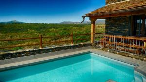 a swimming pool on top of a house at Casa rural El Roble Hueco in Campillejo