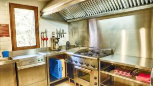 a large kitchen with a stove top oven at Casa rural El Roble Hueco in Campillejo