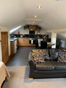 a living room with a couch and a kitchen at Noble Lands in Wooler