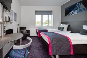 a hotel room with two beds and a table at Cabinn Aalborg in Aalborg