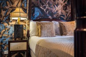 um quarto com uma cama com papel de parede floral em The Howbeck & The Retreat incl off-site Health Club and parking EV POINT AVAILABLE em Windermere