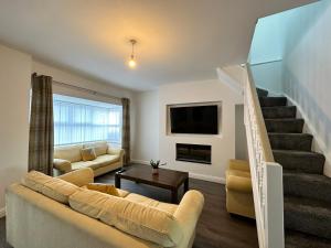 - un salon avec un canapé et un escalier dans l'établissement Belsay 4 bedroom bungalow with loft conversion, à Horden