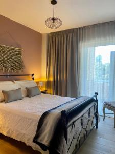 een slaapkamer met een bed en een groot raam bij Cozy flat elix in Lefkandi Chalkidas