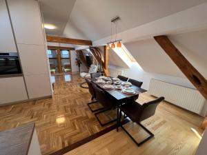 La Luna Rustic Deluxe Apartment with Free Jacuzzi, Bikes & Covered Parking في Našice: غرفة طعام وغرفة معيشة مع طاولة وكراسي