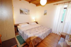 a bedroom with a large bed and two windows at Holiday house in village Rakalj in Rakalj