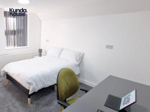 a bedroom with a bed and a desk with a laptop at Kunda House Gillotte in Birmingham