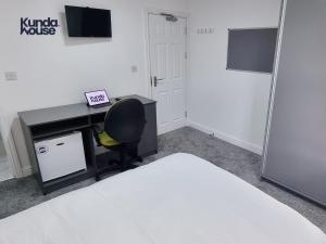 a bedroom with a bed and a desk and a chair at Kunda House Gillotte in Birmingham