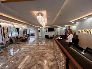 El Emin İstanbul Hotel في إسطنبول: امرأة تقف عند بار في بهو الفندق