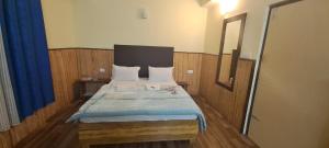 1 dormitorio con 1 cama grande con manta azul en Khi Gha Thang, en Pelling