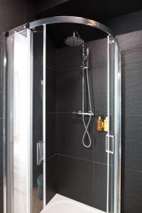 a shower with a glass door in a bathroom at Tuyo Apartments Bokserska in Warsaw