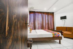 - une chambre avec un lit et un canapé dans l'établissement FabHotel HTC, à Bhopal