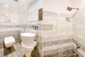 a bathroom with a toilet and a tub at FabHotel HTC in Bhopal