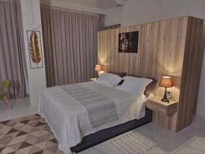 a bedroom with a large bed with a wooden headboard at luxury cheerful 4 bedrooms villa in Calodyne in Calodyne