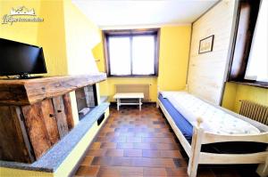 een kamer met 2 bedden en een flatscreen-tv bij Baite Costaccia App 4 in Livigno