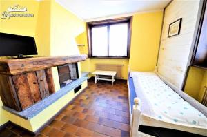 een kleine kamer met een stapelbed en een televisie bij Baite Costaccia App 4 in Livigno